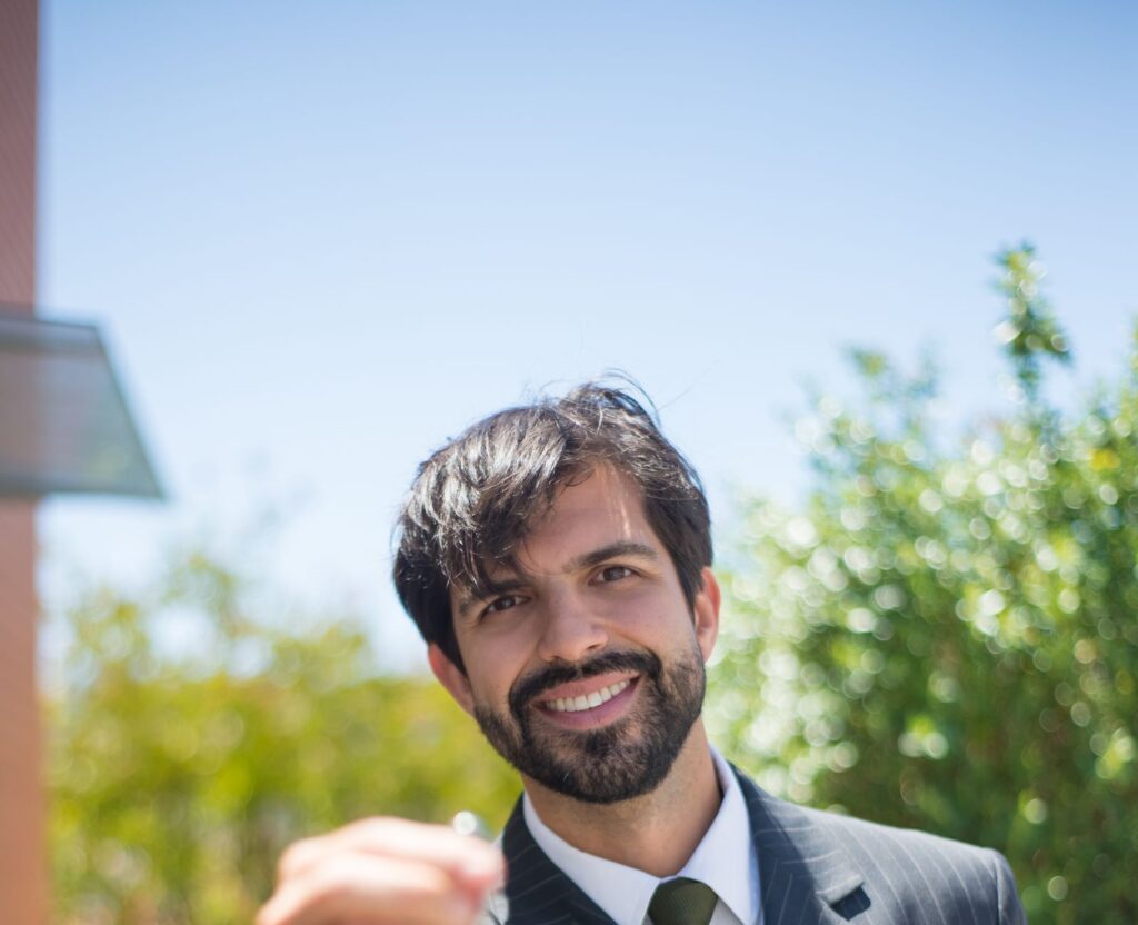 Agent immobilier souriant présentant les clés d'une maison, illustrant vendre avec ou sans agence