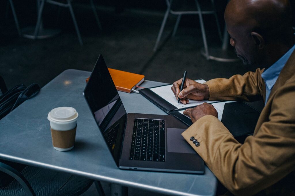 Entrepreneur indépendant travaillant en cafe sur ordinateur, illustrant le statut auto-entrepreneur ou agent commercial