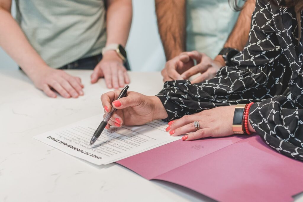 Signature d'une offre d'achat immobilier, illustrant le mandat exclusif ou simple