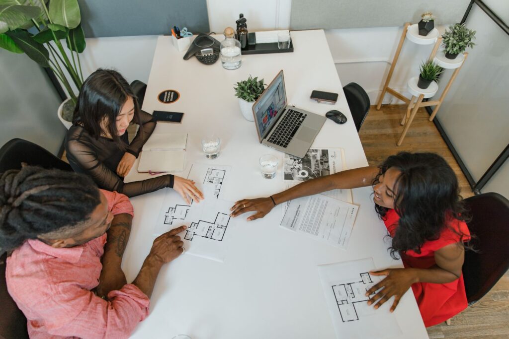 Equipe discutant en réunion de bureau, illustrant la comparaison réseau de mandataires vs agence traditionnelle